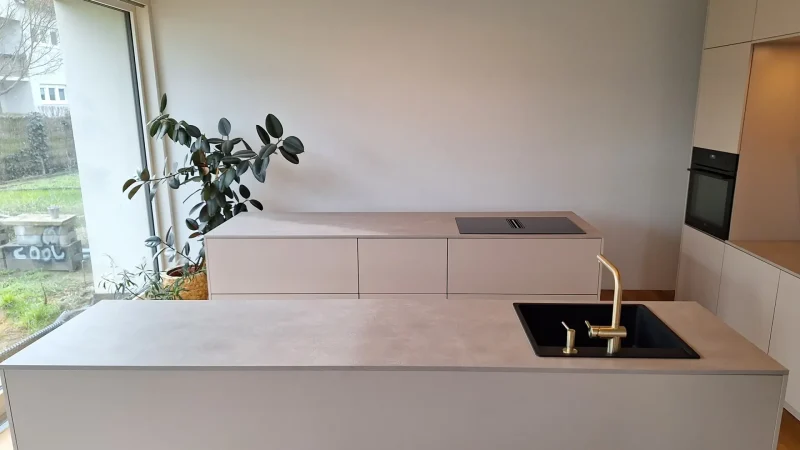 Zweizeilige, weiße Küche im grifflosen Design.